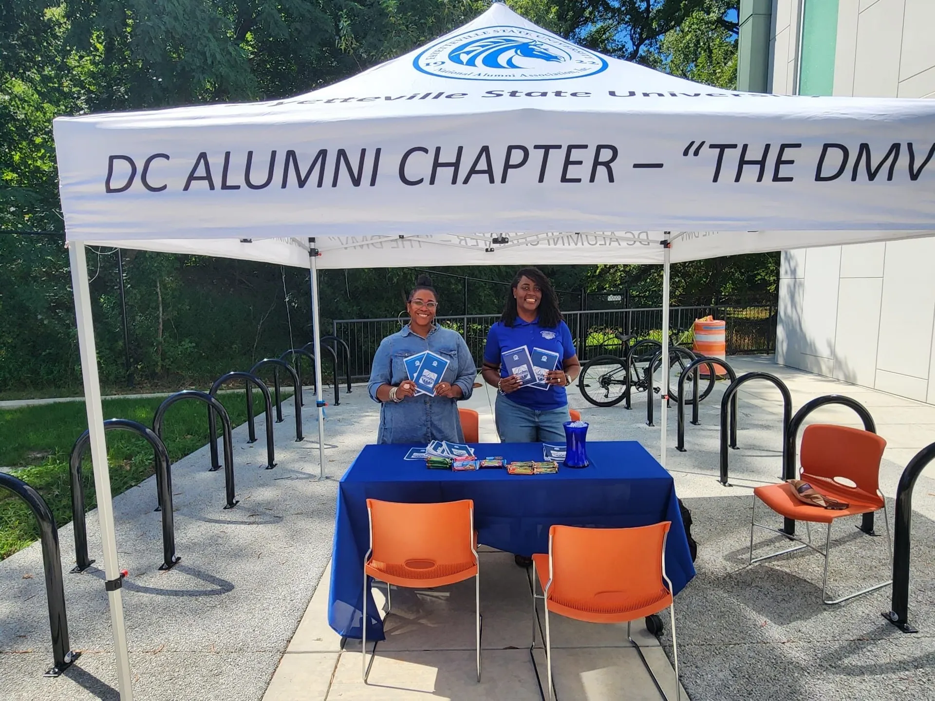 Two FSU DC Alumni Chapter members stand beneath the chapter tent at a community outreach table